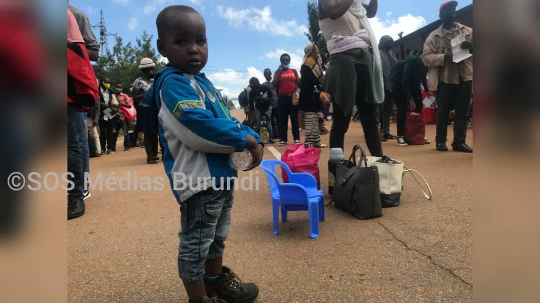 Un petit garçon entre deux lignes de rapatriés burundais à la frontière de Gasenyi-Nemba