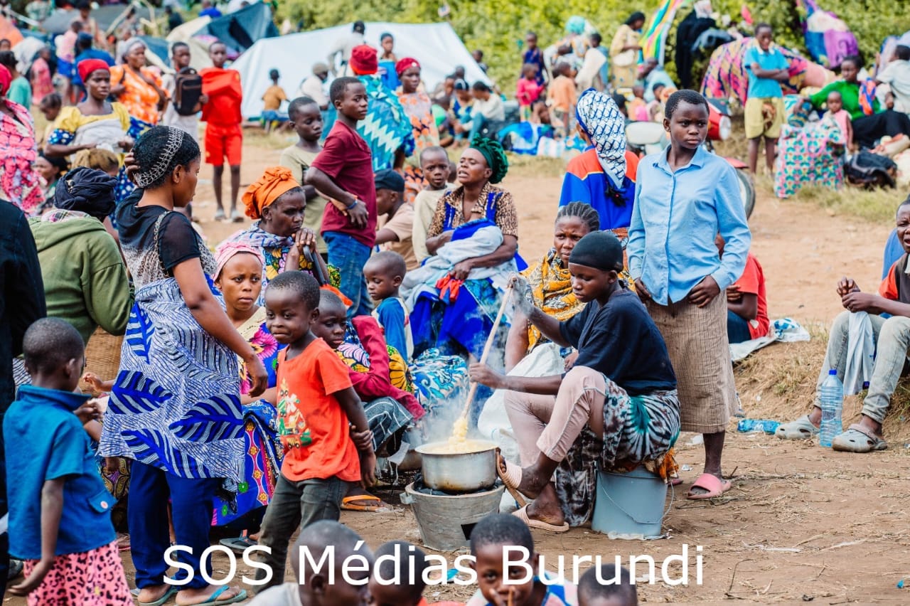 Une réfugiée congolaise prépare de la pâte en plein air dans le camp de la Police nationale du Burundi (PNB) à Gatumba, où des réfugiés ont été abrités dans la précipitation, le 11 décembre 2025. ©SOS Médias Burundi