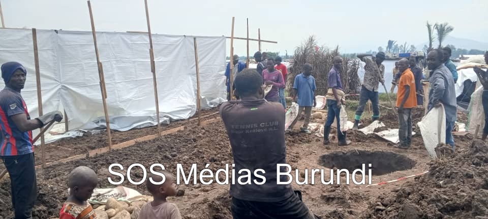 Des hommes s’entraident pour construire des abris de fortune dans un camp de transit destiné aux réfugiés congolais, dans le nord-ouest du Burundi, décembre 2025. ©SOS Médias Burundi
