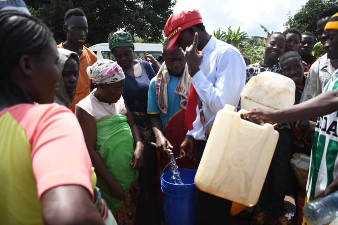 Des hommes et des femmes se pressent autour de l’unique robinet disponible pour s’approvisionner en eau. ©SOS Médias Burundi